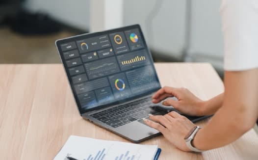 Person analyzing real-time marketing analytics on a laptop dashboard, reviewing performance metrics and campaign insights