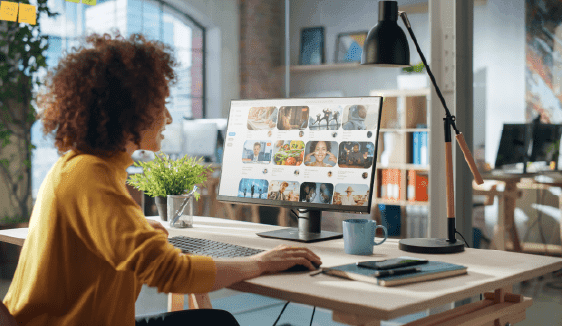 Person creating and adjusting native ad creative on a desktop computer in a modern workspace.